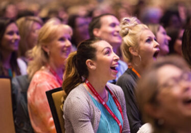 audience listening to speaker reacting in surprise